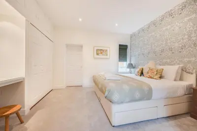 a white bedroom with a bed and a wall at 3 Bed in Aldeburgh oc-9king in Aldeburgh