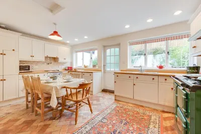 a kitchen with white cabinets and a table and chairs at 3 Bed in Woodbridge oc-acot in Woodbridge