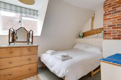 a bedroom with a bed and a dresser with a mirror at 3 Bed in Woodbridge oc-acot in Woodbridge