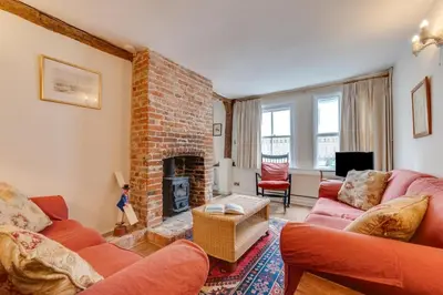 a living room with red furniture and a brick fireplace at 3 Bed in Woodbridge oc-acot in Woodbridge