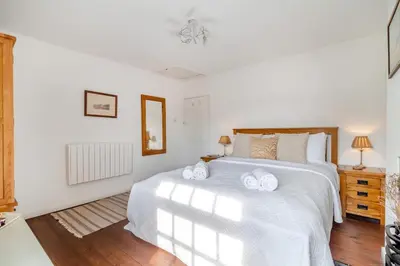 a bedroom with a white bed with two towels on it at 2 Bed in Orford oc-sfcto in Orford