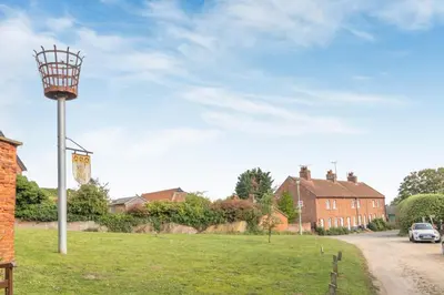a basketball hoop in the middle of a field with houses at 2 Bed in Orford oc-sfcto in Orford