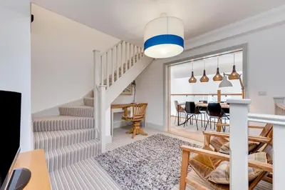 a living room with a staircase and a dining room at 4 Bed in Thorpeness oc-barrh in Thorpeness