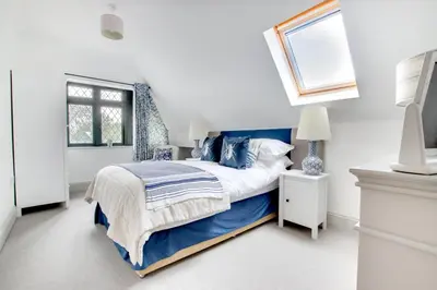 a bedroom with a blue and white bed and a window at 4 Bed in Thorpeness oc-barrh in Thorpeness