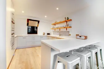 a kitchen with a white counter and stools at 4 Bed in Thorpeness oc-barrh in Thorpeness