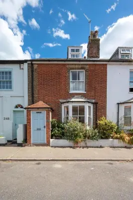 a brick house with blue doors on a street at 3 Bed in Aldeburgh oc-ahs in Aldeburgh
