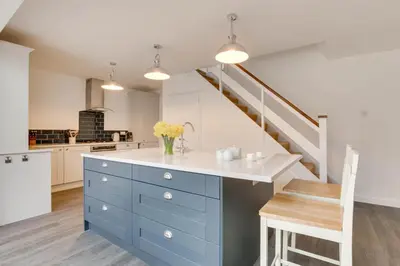 a kitchen with blue cabinets and a staircase at 3 Bed in Woodbridge oc-30mor in Woodbridge