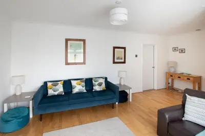 a living room with a blue couch and a table at 3 Bed in Woodbridge oc-30mor in Woodbridge