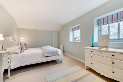 a white bedroom with a bed and a dresser at 6 Bed in Knodishall oc-bil in Aldringham