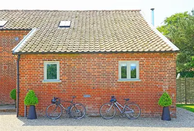 two bikes parked in front of a brick house at 6 Bed in Knodishall oc-bil in Aldringham