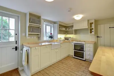 a kitchen with white cabinets and a sink and a window at 2 Bed in Iken oc-sfboo in Sudbourne