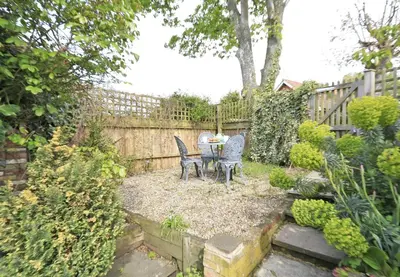 a garden with a table and chairs and a fence at 2 Bed in Snape oc-sfbox in Snape