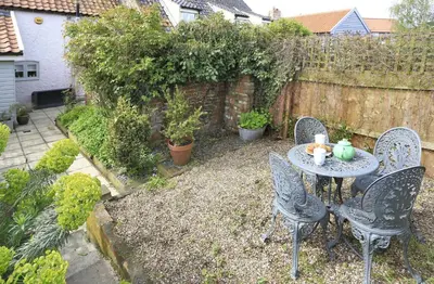 a patio with a table and chairs and a fence at 2 Bed in Snape oc-sfbox in Snape