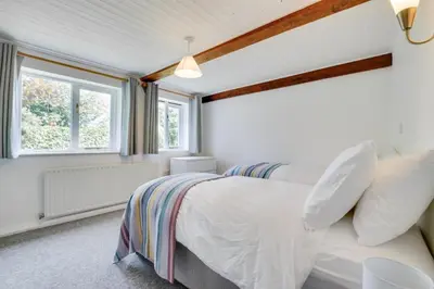 a bedroom with two beds and two windows at 4 Bed in Eastbridge oc-bricot in Theberton