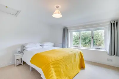 a bedroom with a bed with a yellow blanket and a window at 4 Bed in Eastbridge oc-bricot in Theberton