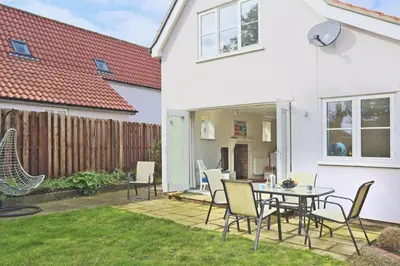a patio with a table and chairs in a yard at 4 Bed in Friston oc-colu in Friston