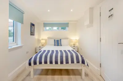 a small bedroom with a bed and two windows at 4 Bed in Friston oc-colu in Friston