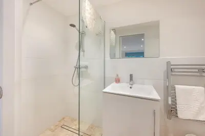 a white bathroom with a shower and a sink at 4 Bed in Friston oc-colu in Friston