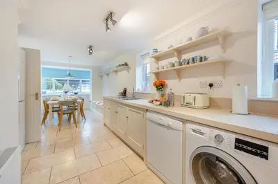 a kitchen with a washing machine and a dining room at 4 Bed in Friston oc-colu in Friston
