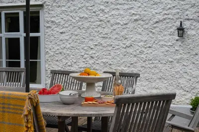 a table with a bowl of fruit on a patio at 5 Bed in Halesworth oc-cfl in Halesworth