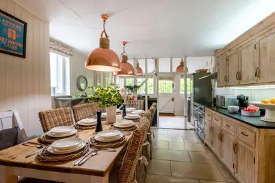 a kitchen with a wooden table with plates and utensils at 5 Bed in Halesworth oc-cfl in Halesworth