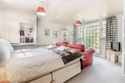 a bedroom with a large bed and two red chairs at 1 Bed in Yoxford oc-c27254 in Wickham Market