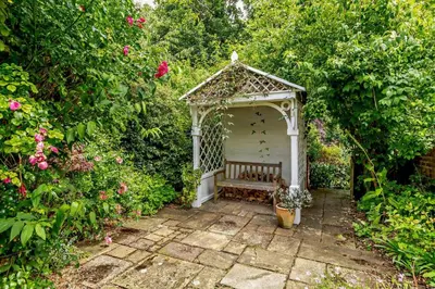 a white gazebo with a bench in a garden at 1 Bed in Yoxford oc-c27254 in Wickham Market