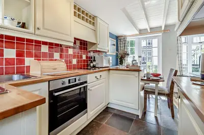 a kitchen with white cabinets and a stove top oven at 1 Bed in Yoxford oc-c27254 in Wickham Market