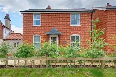 a brick house with a wooden fence in front of it at 3 Bed in Eastbridge oc-cob in Theberton