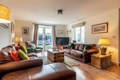 a living room with leather furniture and a television at 3 Bed in Eastbridge oc-cob in Theberton