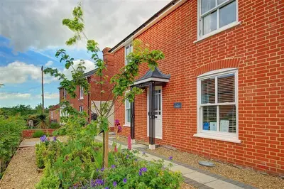 a red brick house with a garden in front of it at 3 Bed in Eastbridge oc-cob in Theberton