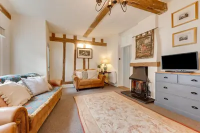 a living room with a couch and a flat screen tv at 2 Bed in Lavenham oc-24ss in Lavenham