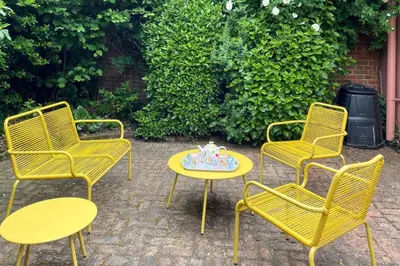 three yellow chairs and a table with a cake on it at 2 Bed in Lavenham oc-24ss in Lavenham