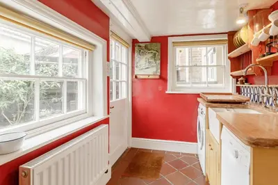 a kitchen with red walls and windows at 4 Bed in Aldeburgh oc-sfcrr in Aldeburgh