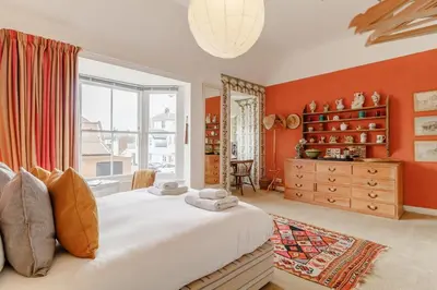 a bedroom with orange walls and a large bed at 4 Bed in Aldeburgh oc-sfcrr in Aldeburgh