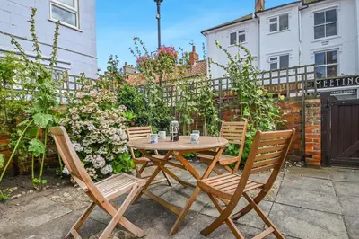 a wooden table and chairs in a garden at 2 Bed in Aldeburgh oc-sfdar in Aldeburgh
