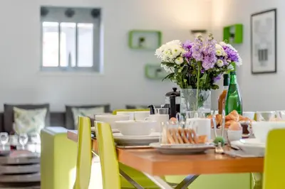 a dining room table with a vase of flowers at 3 Bed in Knodishall oc-ebco in Aldringham