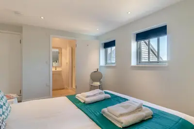 a bedroom with two towels sitting on a bed at 3 Bed in Knodishall oc-ebco in Aldringham