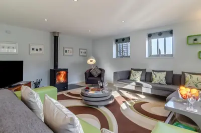 a living room with a couch and a fireplace at 3 Bed in Knodishall oc-ebco in Aldringham