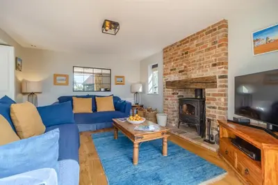 a living room with a blue couch and a fireplace at 3 Bed in Westleton Saxmundham oc-est in Westleton