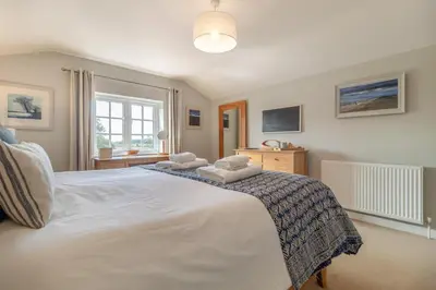 a bedroom with a large white bed with towels on it at 3 Bed in Westleton Saxmundham oc-est in Westleton