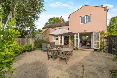 a patio with a table with chairs and an umbrella at 3 Bed in Westleton Saxmundham oc-est in Westleton