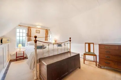 a bedroom with a bed and a dresser and a chair at 3 Bed in Hemley oc-g91 in Hemley