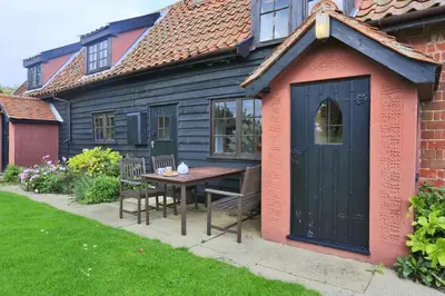 a small house with a table and a black door at 3 Bed in Hemley oc-g91 in Hemley