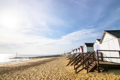 a row of beach houses on a sandy beach at 3 Bed in Felixstowe oc-fel in Felixstowe
