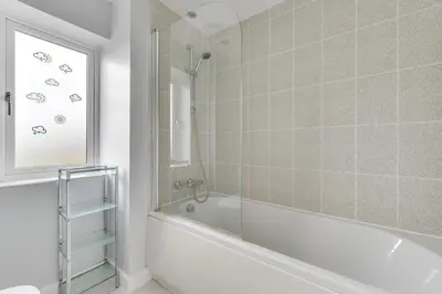 a bathroom with a bath tub and a window at 3 Bed in Felixstowe oc-fel in Felixstowe