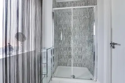 a shower with a glass door in a bathroom at 3 Bed in Felixstowe oc-fel in Felixstowe