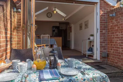 a table with plates and glasses on a patio at 2 Bed in Aldeburgh oc-fsh in Aldeburgh