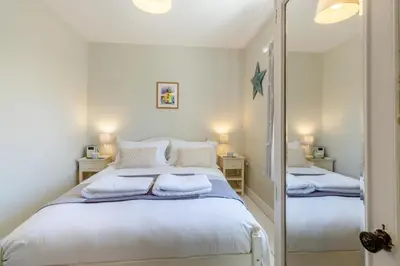 a bedroom with two beds with white sheets and a mirror at 2 Bed in Aldeburgh oc-fsh in Aldeburgh