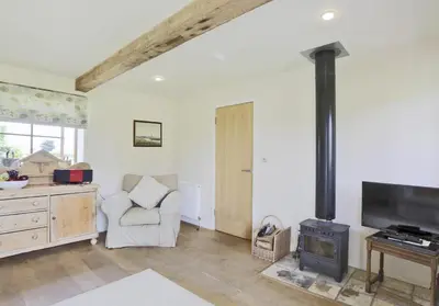 a living room with a wood stove and a chair at 2 Bed in Yoxford oc-hharro in Yoxford